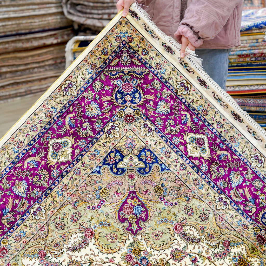 Isfahan Ivory & Amethyst Silk Rug being held for better visuals 