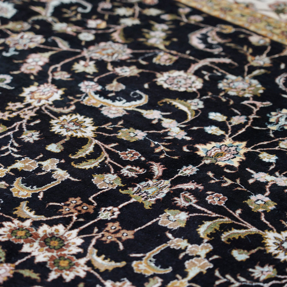 Close-up of a black floral patterned rug