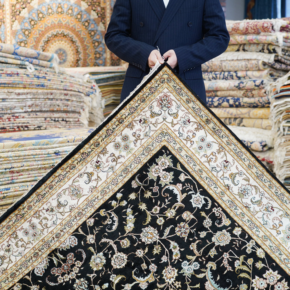 Holding The Tabriz Noir Garden Rug
